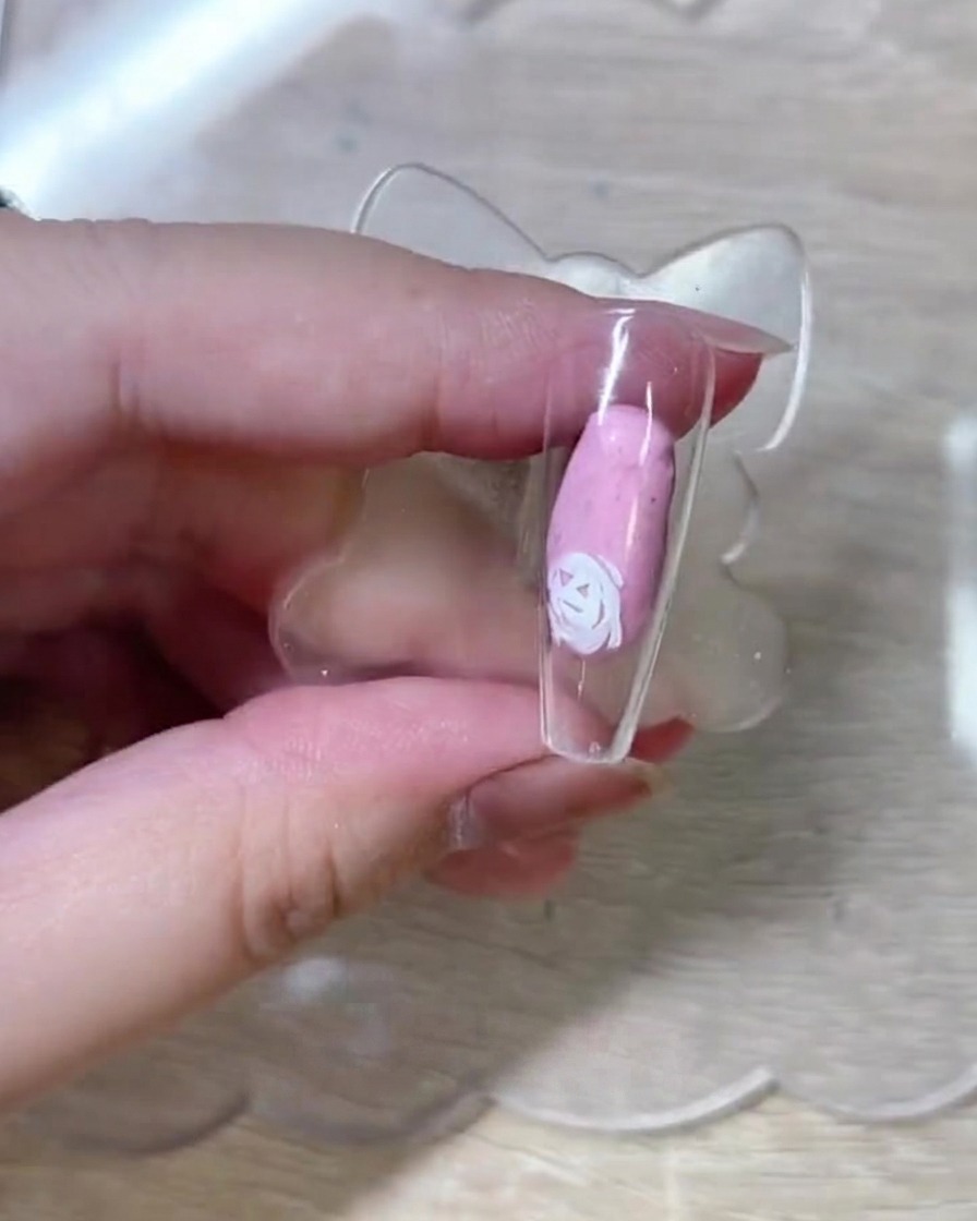 Vue rapprochée montrant le tracé de nouveaux contours de roses sur la capsule, enrichissant la composition florale.