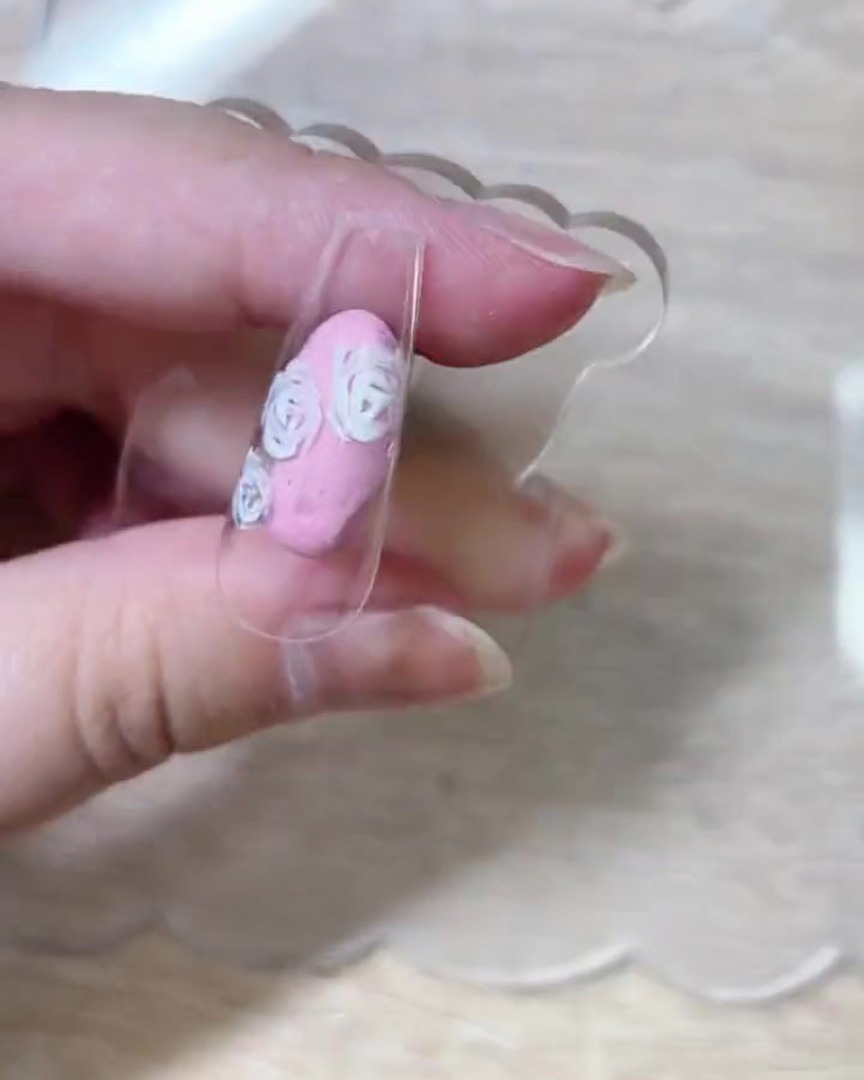 Vue de dessus de la capsule montrant les contours complets des pétales de roses répartis sur toute la surface.