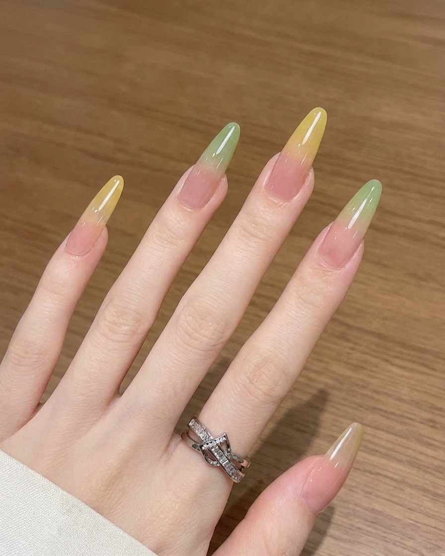Vue rapprochée montrant un pinceau ombré estompant du gel jaune vers le haut sur un ongle.