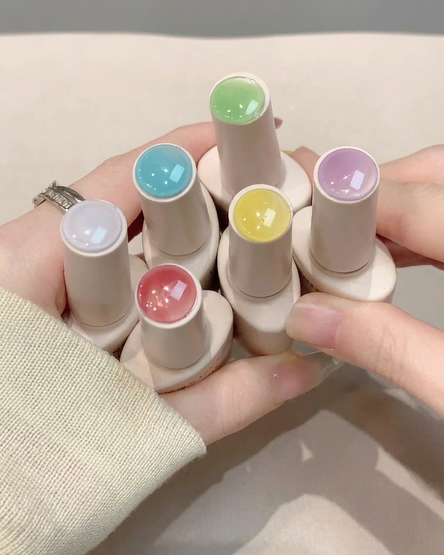 Un pinceau à ongles appliquant une couche de finition transparente et brillante sur un nail art terminé.