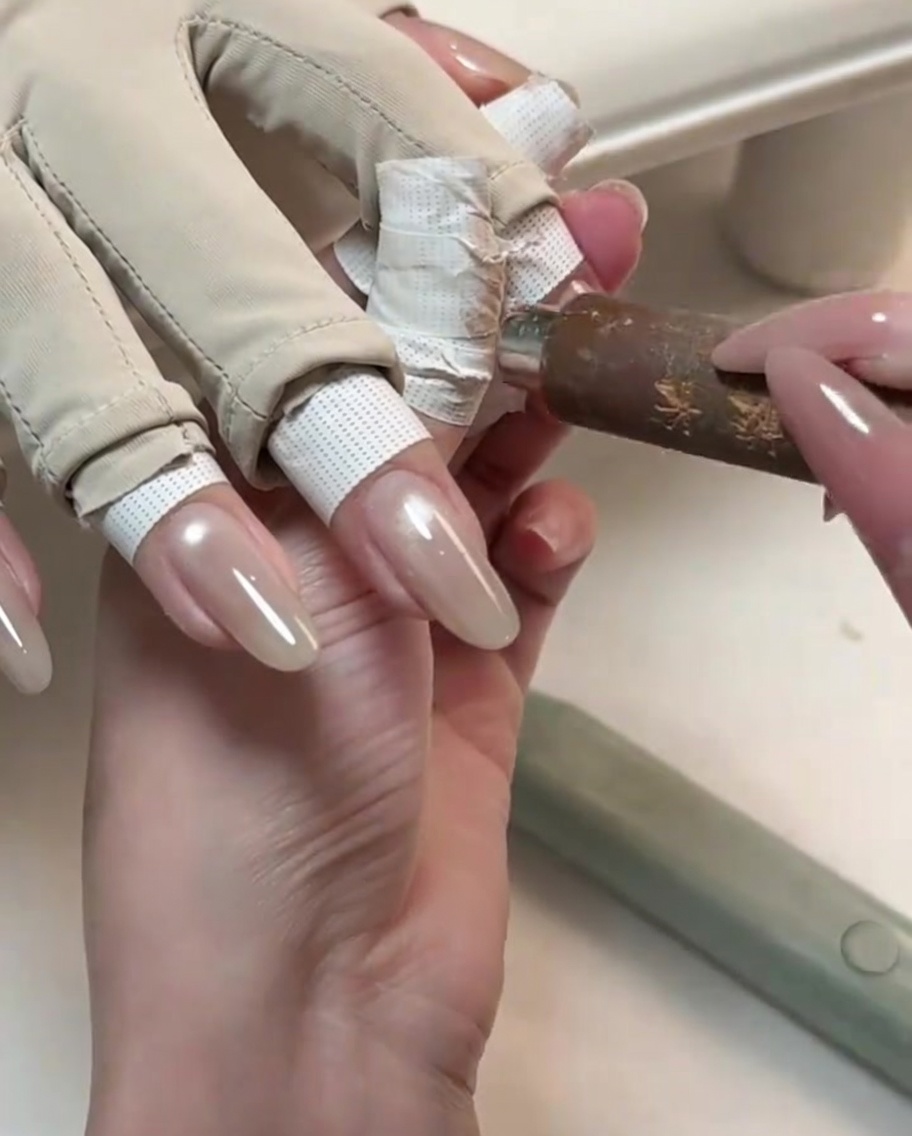 Un outil magnétique tenu près dun ongle brillant pour créer une ligne de lumière cat-eye.