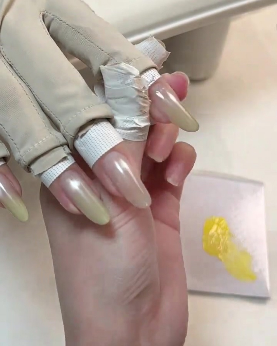 Un outil affinant la seconde couche de gel jaune sur le bout de longle pour un dégradé plus vif.
