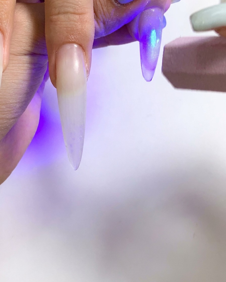 Une petite lampe torche UV utilisée pour catalyser un seul ongle avec un effet cat eye.