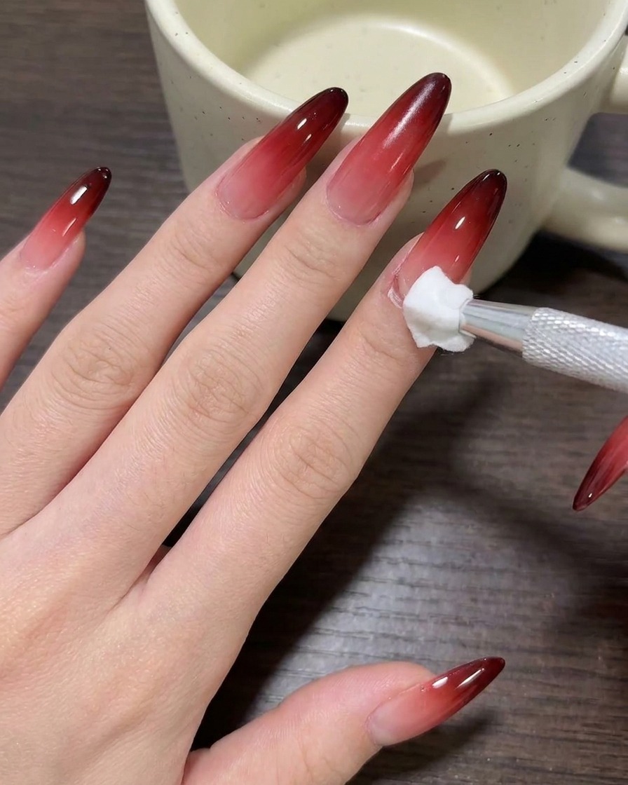Gros plan dun pinceau appliquant du vernis gel nude thé au lait sur un onglet propre.