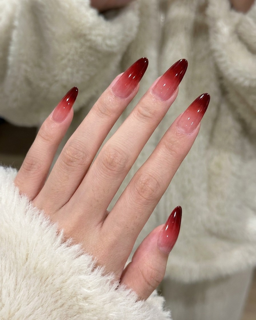 La deuxième application de gel rouge étant tapotée sur longle pour intensifier la couleur du dégradé.