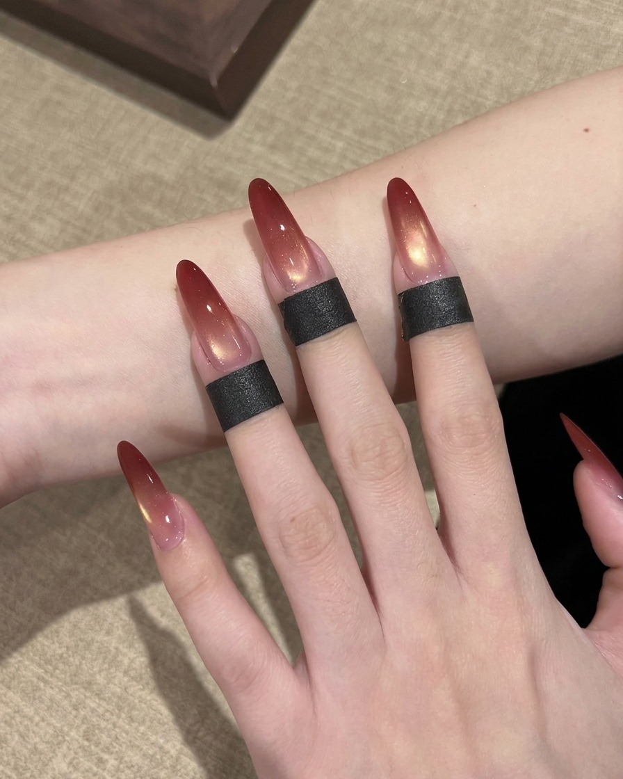 Gros plan dun pinceau à ongles appliquant du vernis gel rouge sur le bout dun faux ongle long en forme damande.