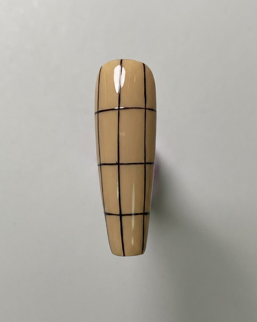 Un ongle de couleur nude avec trois lignes verticales et trois lignes horizontales uniformément espacées, créant un grand quadrillage.