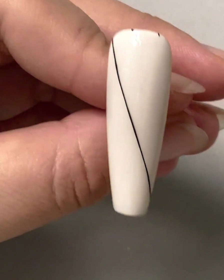 Gros plan dun ongle montrant de petits points despacement noirs marqués le long de la section vierge supérieure droite.