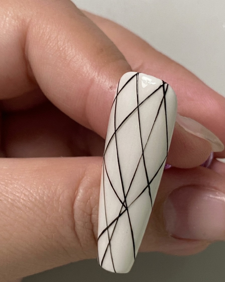Gros plan dun ongle montrant de petits points despacement noirs marqués le long de la section inférieure.