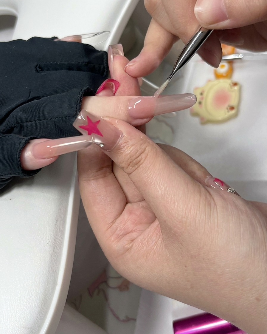 Vue rapprochée dun outil de précision et dune petite éponge nettoyant autour du bord dun ongle préparé.