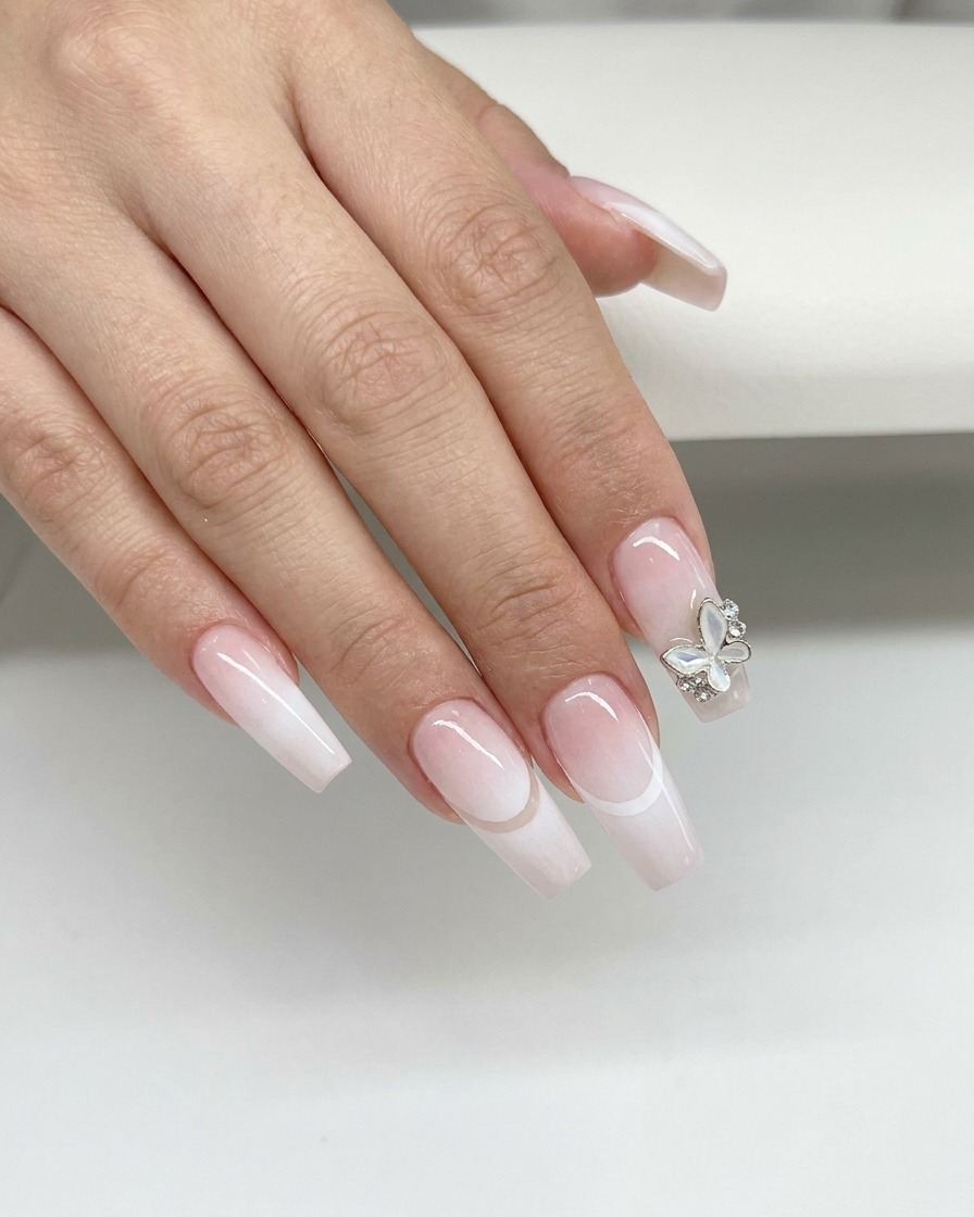 Un outil de maquillage en silicone bleu essuyant la ligne de sourire incurvée dun ongle pour nettoyer lexcès de gel blanc.