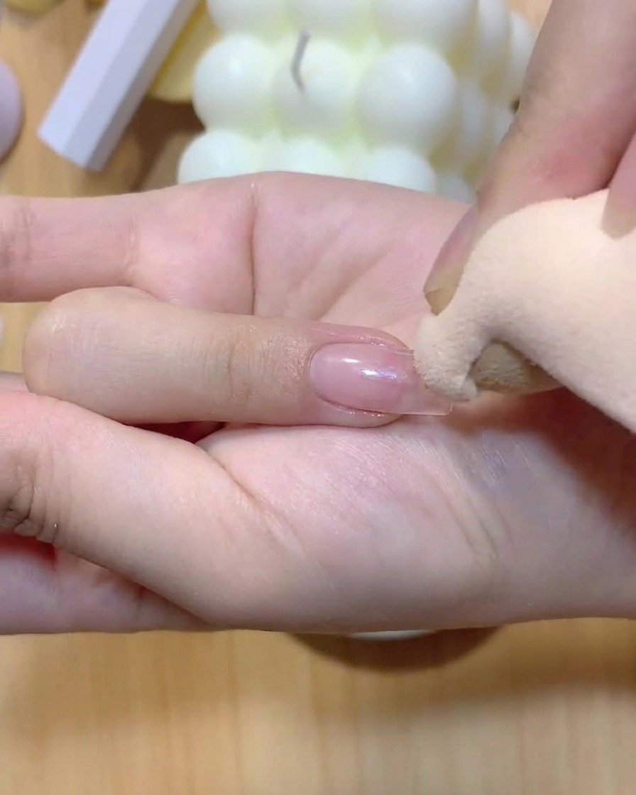 Une éponge à maquillage tapotant doucement de la couleur sur un ongle pour créer un dégradé ombré.