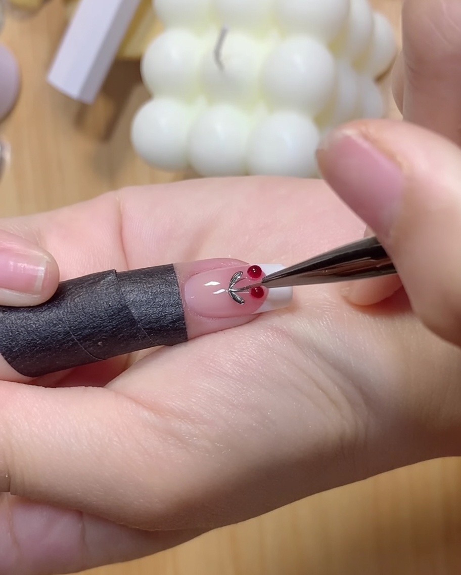 Un doigt appuyant légèrement sur deux boules de gel transparent sur la surface dun ongle.