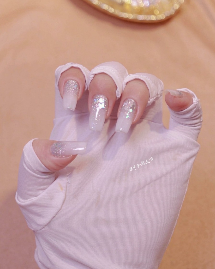 Une main positionnée sous une lampe à ongles pour catalyser la couche de nail art fraîchement appliquée.