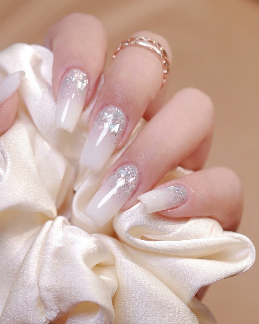 Un pinceau appliquant une couche de finition brillante uniformément sur la surface dun ongle décoré.