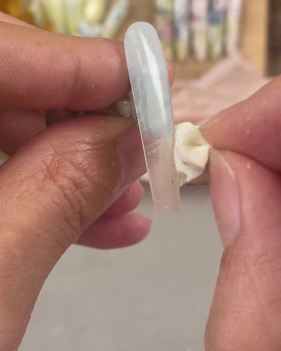 Une éponge à cosmétiques tapotant une deuxième couleur sur le bout de lextension dongle pour fondre leffet ombré.