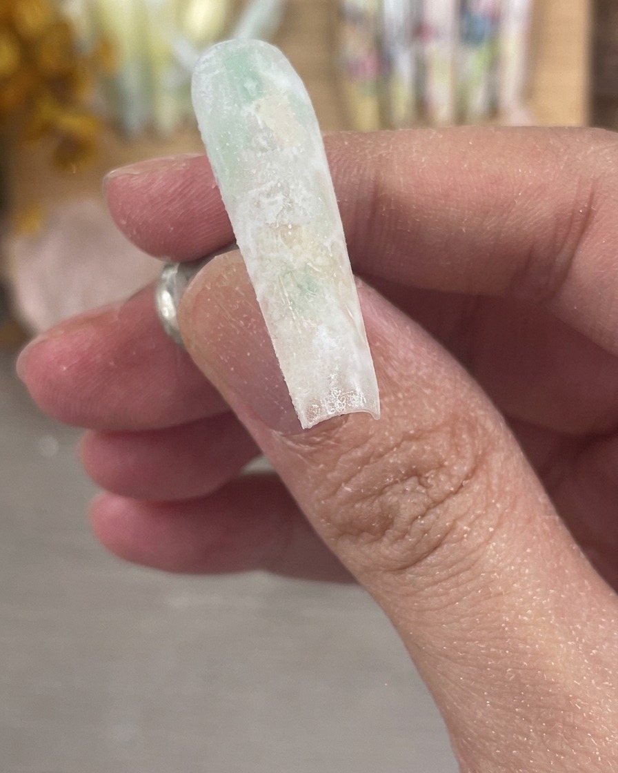 Gros plan dun ongle parfaitement limé et poli montrant une surface mate et dépolie.