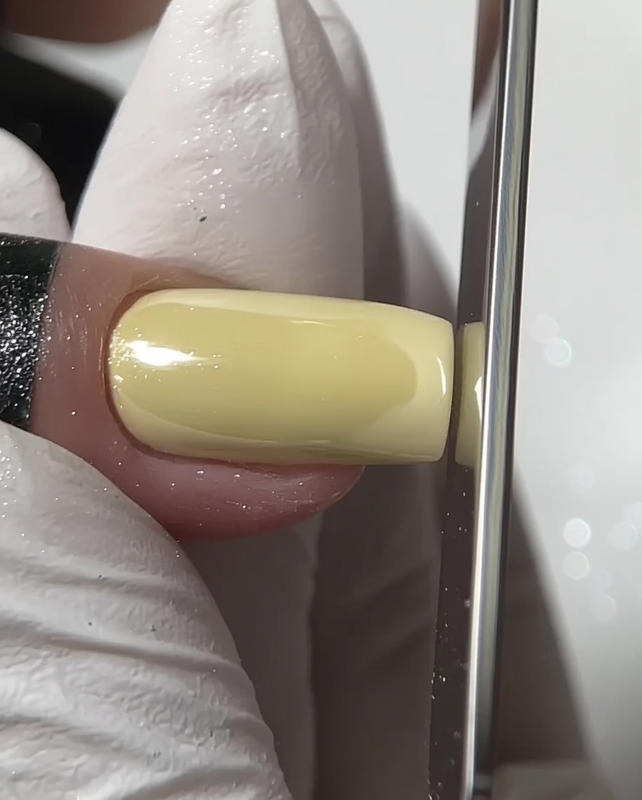 Une lime à ongles façonnant le bord libre dun ongle carré chromé.