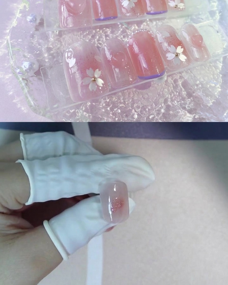 Un doigt ganté tenant une capsule dongle avec un centre blush rose et une touche de gel pailleté.