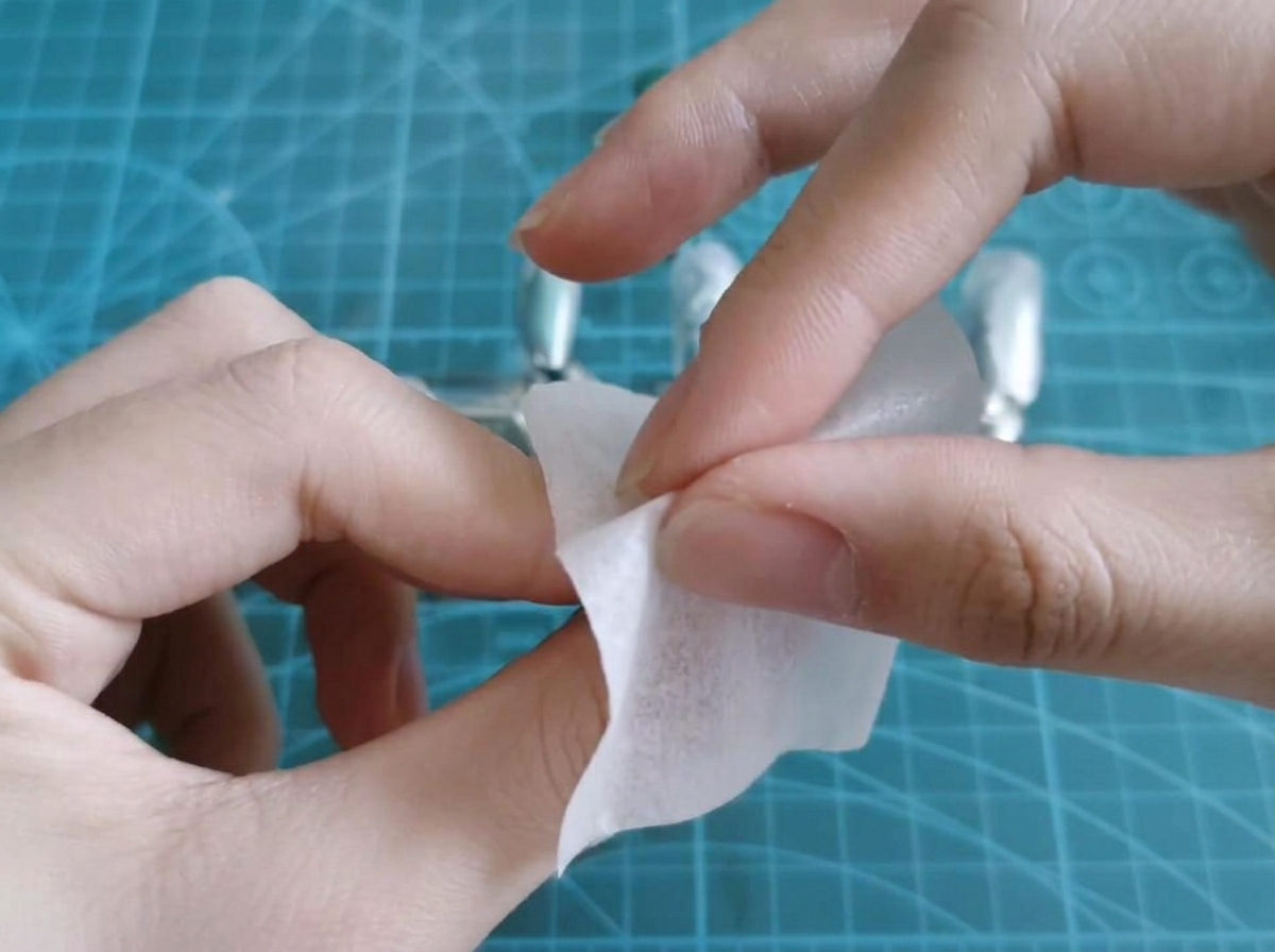 Une lingette imbibée dalcool nettoyant le résidu collant dune capsule en gel catalysée.