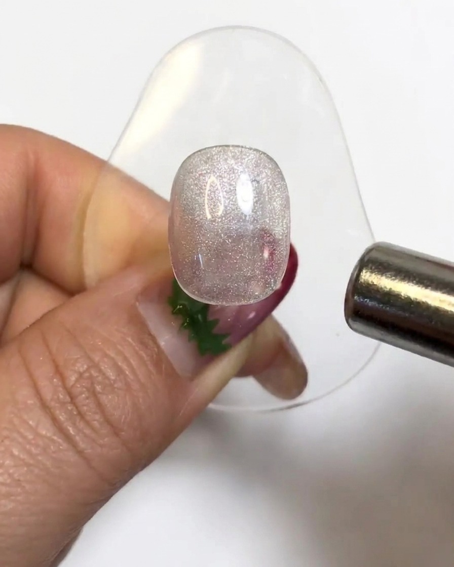 Un aimant cylindrique survolant une capsule dongle en gel brillant pour activer les particules cat eye.