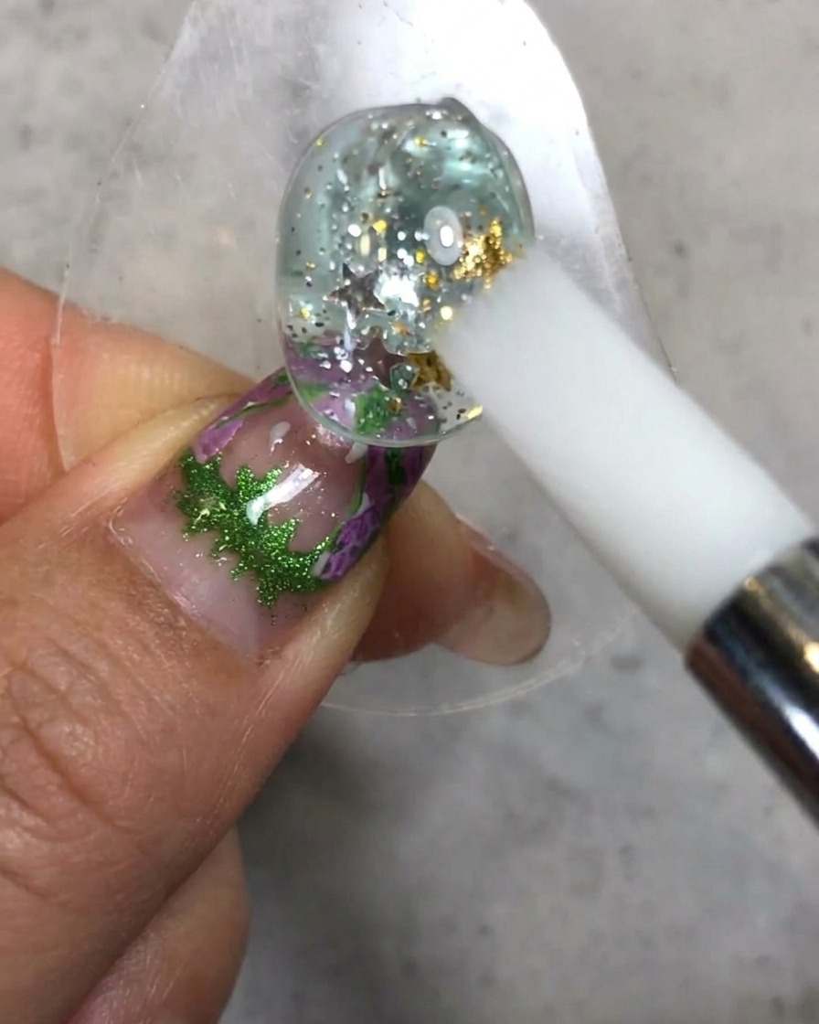 Un stylo en silicone blanc sculptant et lissant la texture du soft candy gel sur le dessus de la surface de longle décoré.
