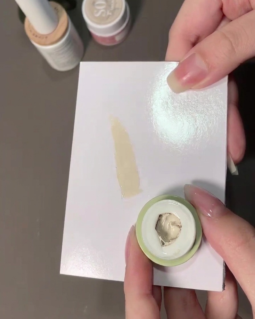 Une éponge prélevant du gel de rembourrage blanc lait sur une palette.
