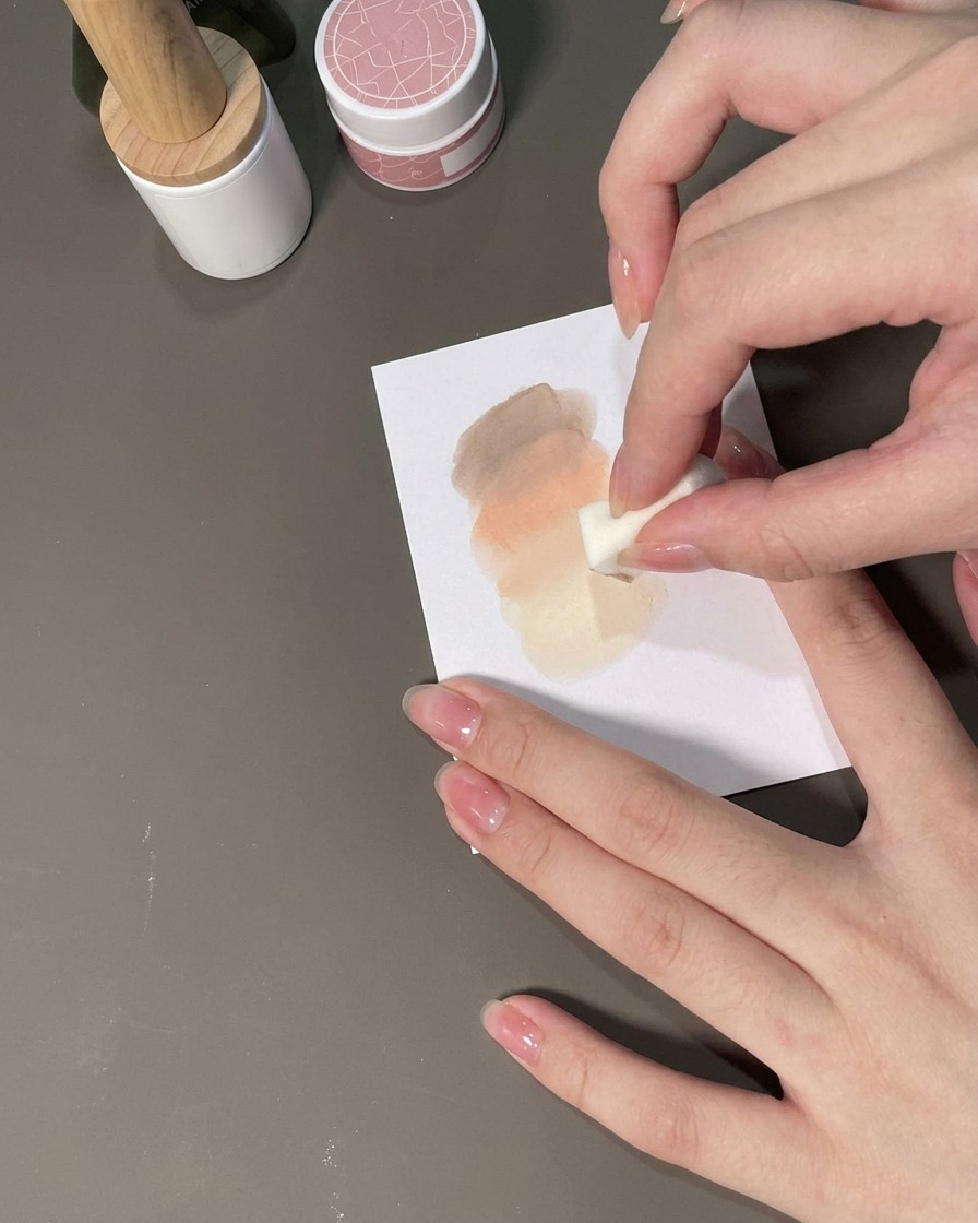 Une éponge tapotant du gel sur un ongle pour former un dégradé ombré.