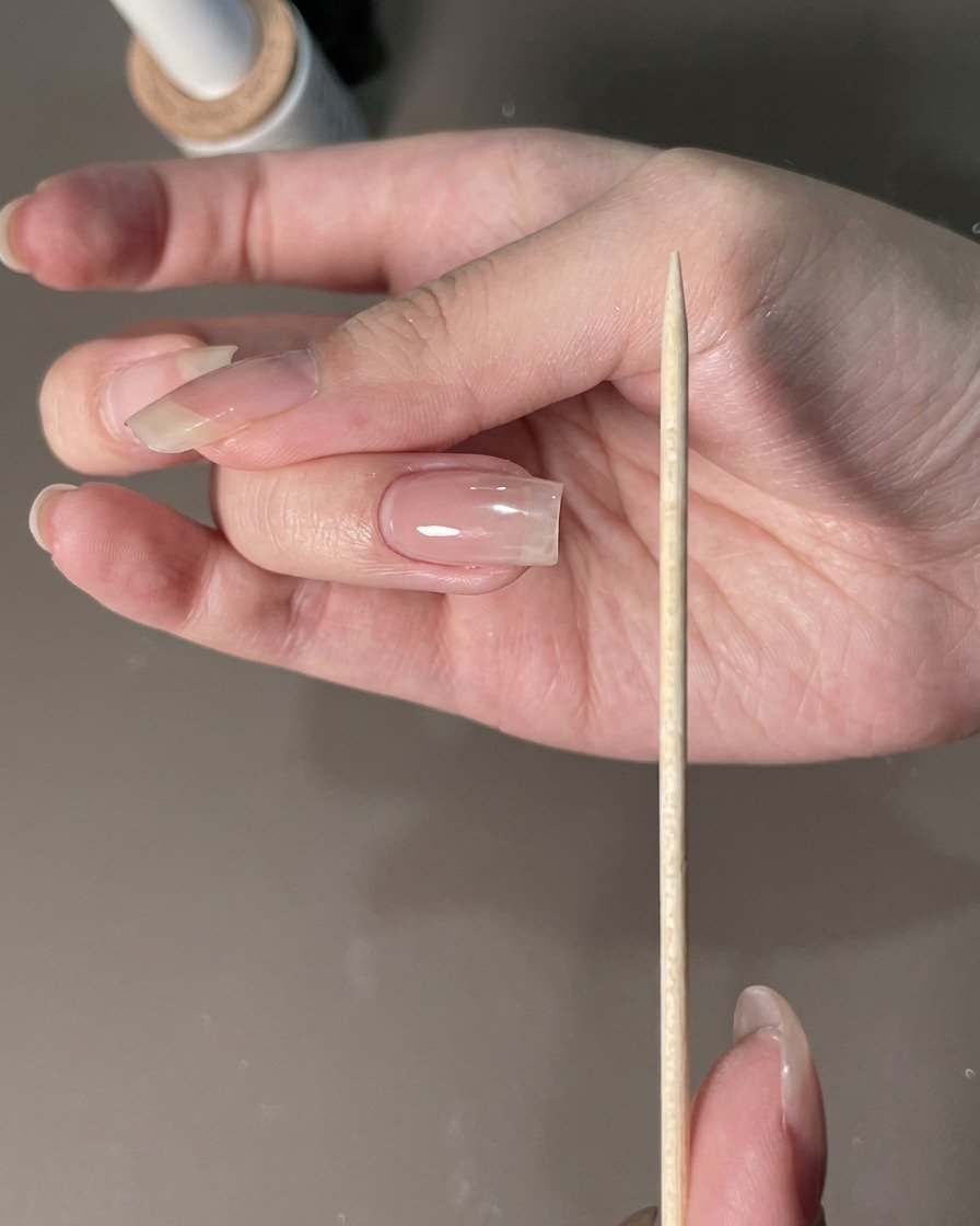 Une lime à ongles maintenue près dune main manucurée pour sculpter les contours.