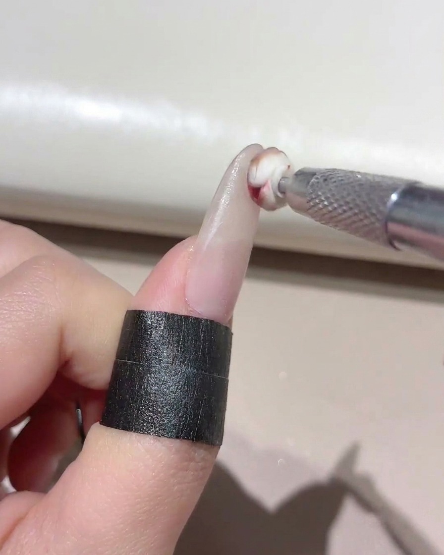Un petit outil éponge appliquant du gel mélangé sur le bout dun ongle manucuré.