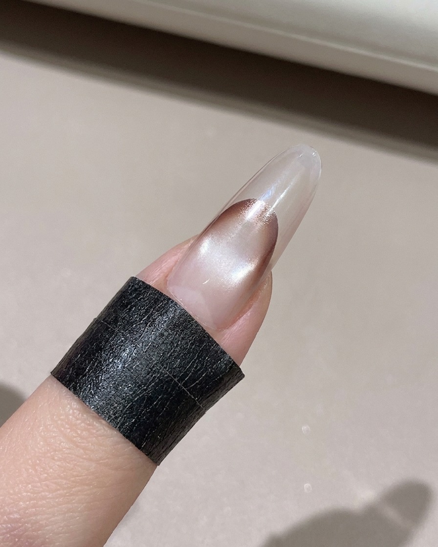 Une lingette non pelucheuse nettoyant lexcès de gel sur le bord dun ongle décoré.