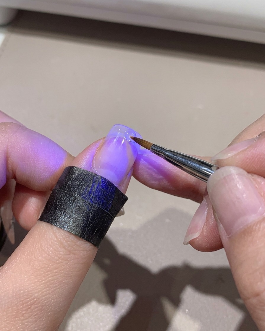 Une mini lampe UV catalysant une pointe dongle dégradée tout en étant tenue à la main.