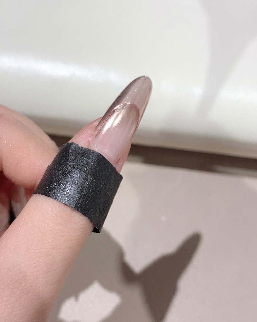 Un pinceau souple balayant lexcès de poudre dun ongle manucuré brillant.