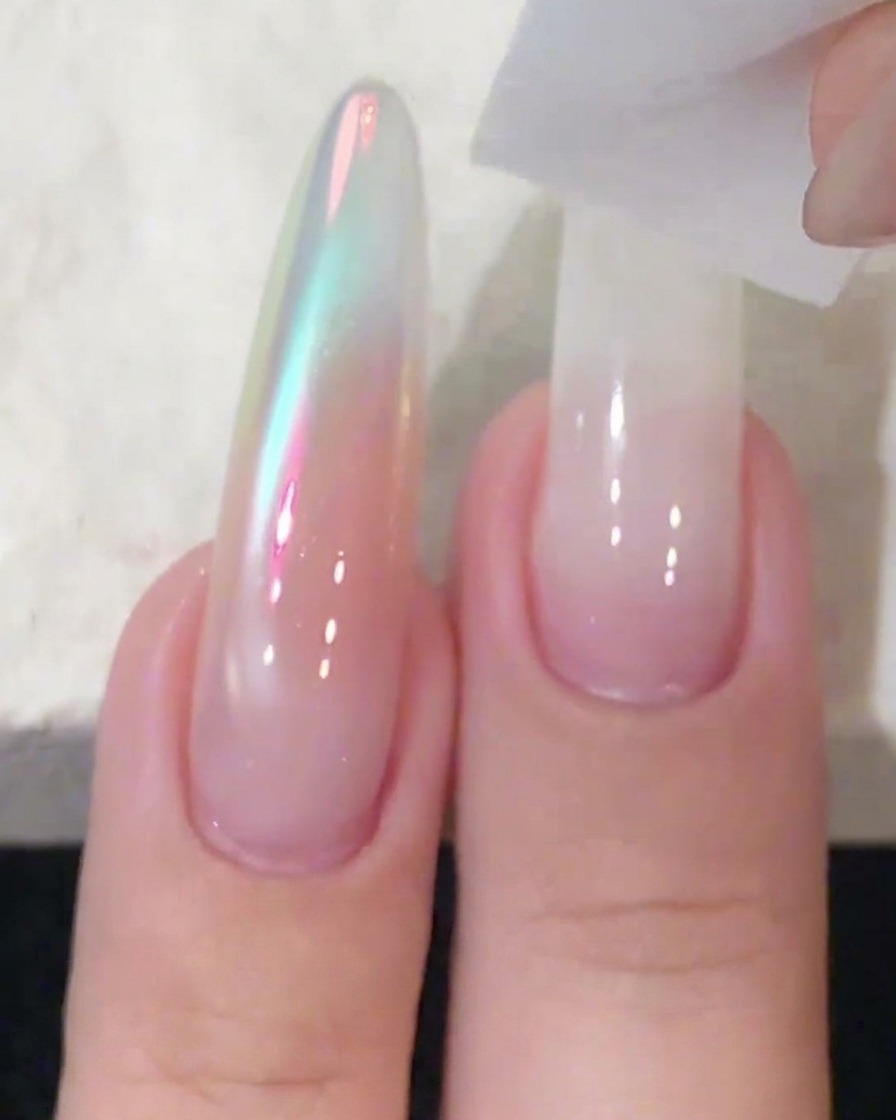 Un bloc éponge utilisé pour tapoter et estomper le vernis gel blanc sur une extension dongle long.