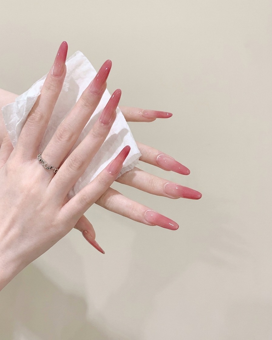 Vue rapprochée dune paire de mains nettoyant de longs ongles stiletto avec un mouchoir blanc humide.