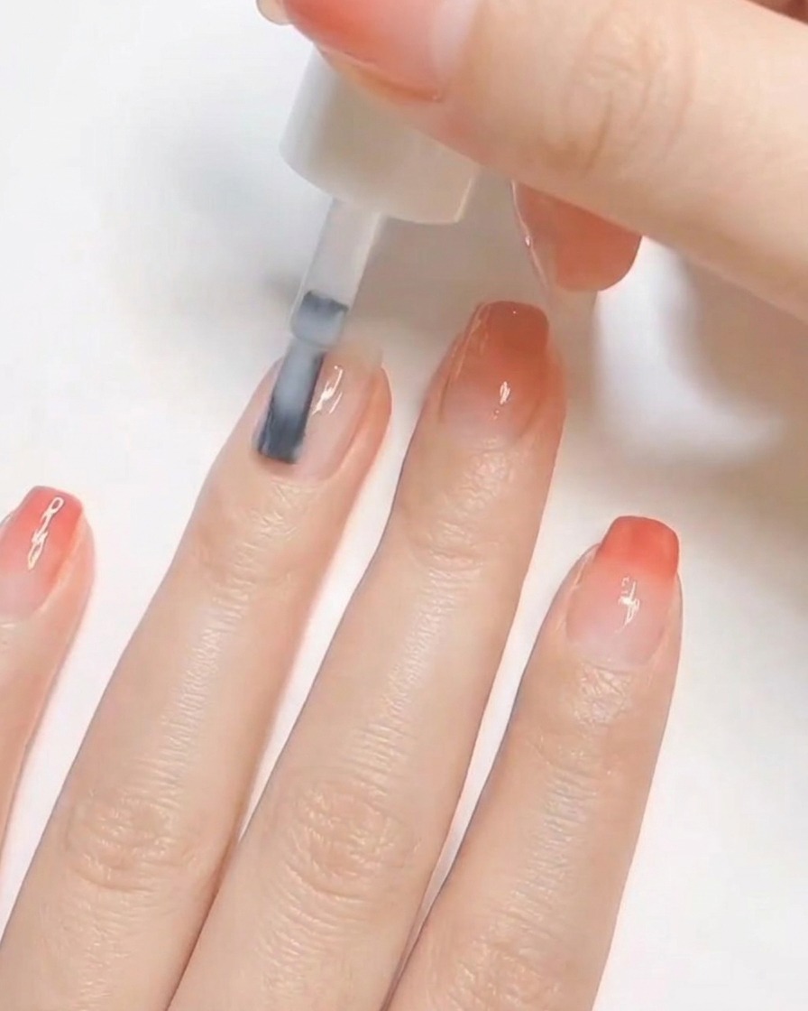 Un pinceau appliquant une couche de vernis blanc opaque sur un ongle naturel préparé.
