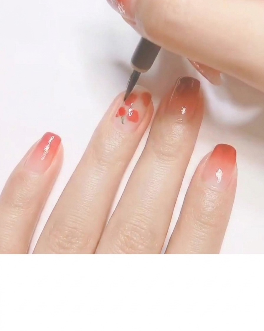 Un pinceau fin ajoutant des petites feuilles vertes et des reflets blancs sur des formes rouges, créant un motif de pêche.