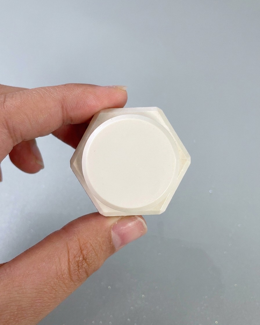 Une éponge de maquillage tamponnant du gel de peinture blanc sur les bords de la surface dun ongle peint.