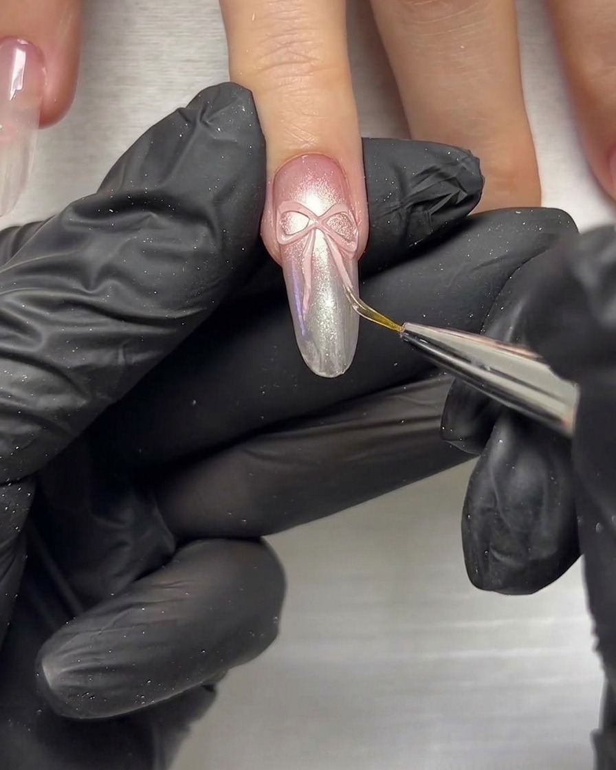 Gros plan dun outil de modelage utilisé pour presser et façonner les éléments du ruban 3D sur un ongle.