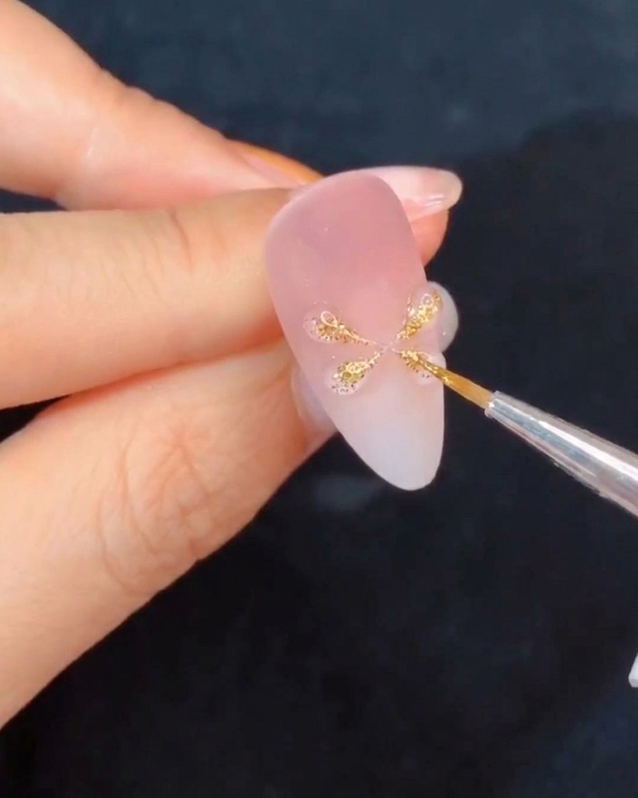 Une main plaçant un ongle sous une lampe de catalysation, mettant en valeur les nouveaux détails en gel.