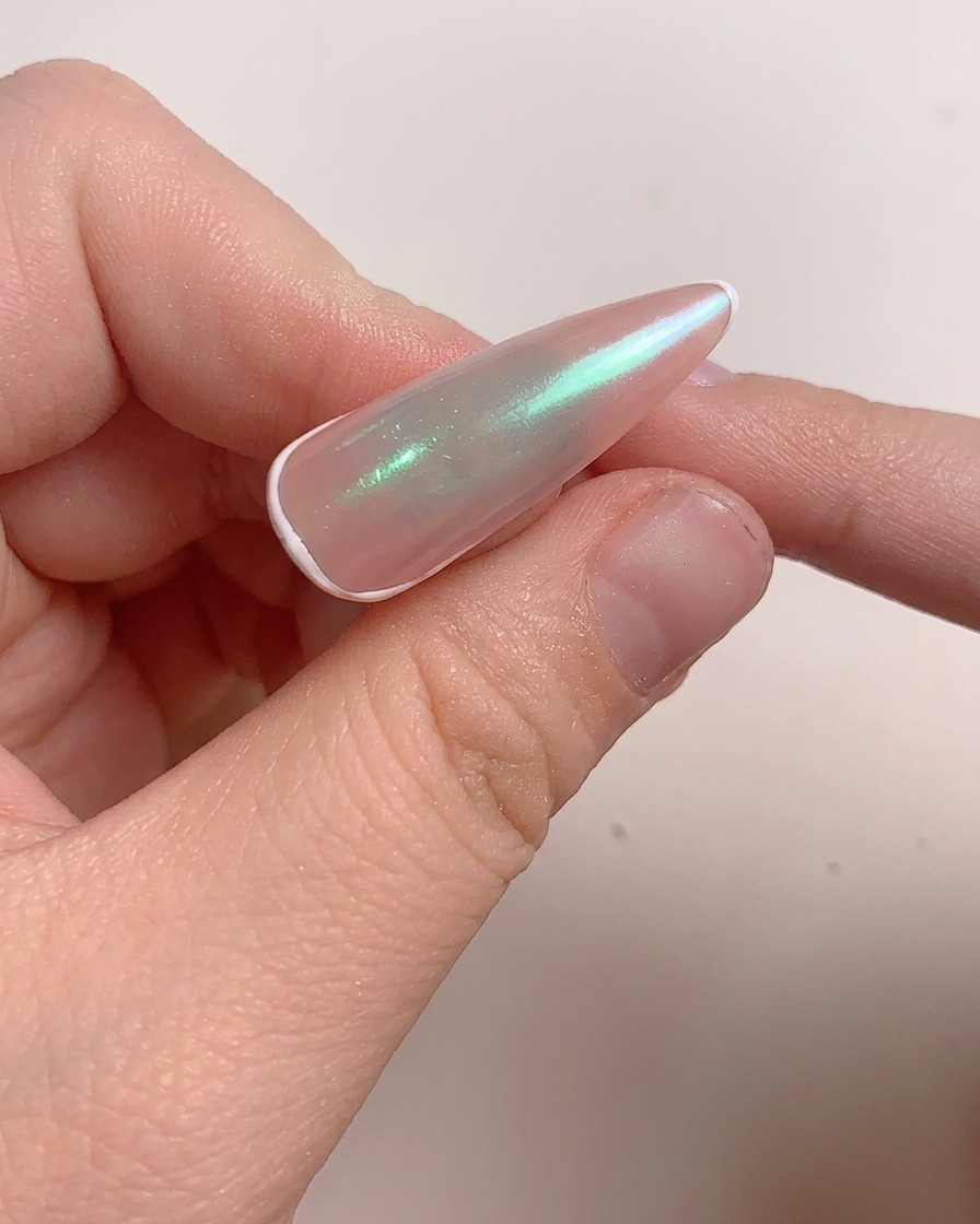 Un pinceau appliquant une couche de gel de construction sur longle poli.