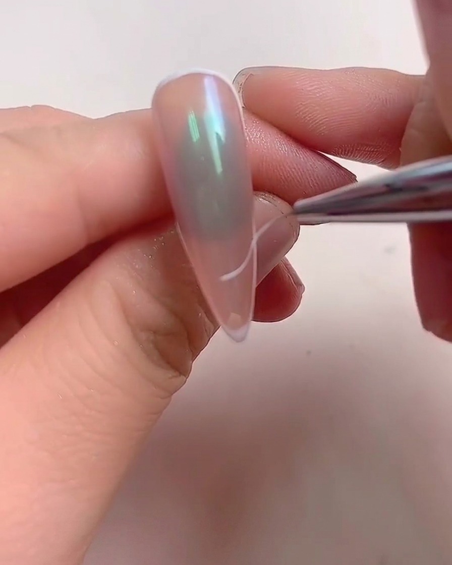 Une main placée dans une lampe à ongles professionnelle UV/LED avec une lumière violette éclairant les doigts.