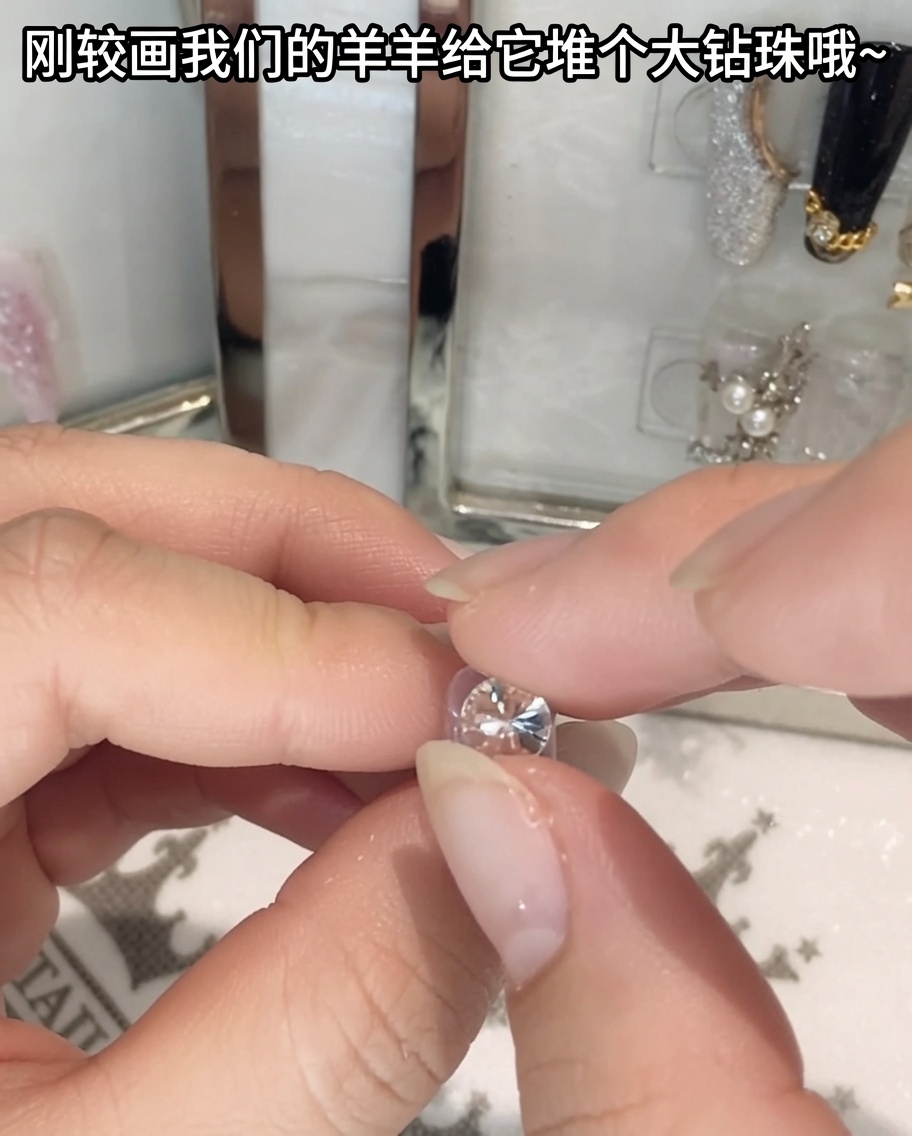 Une paire de brucelles tenant et positionnant un grand strass en cristal.