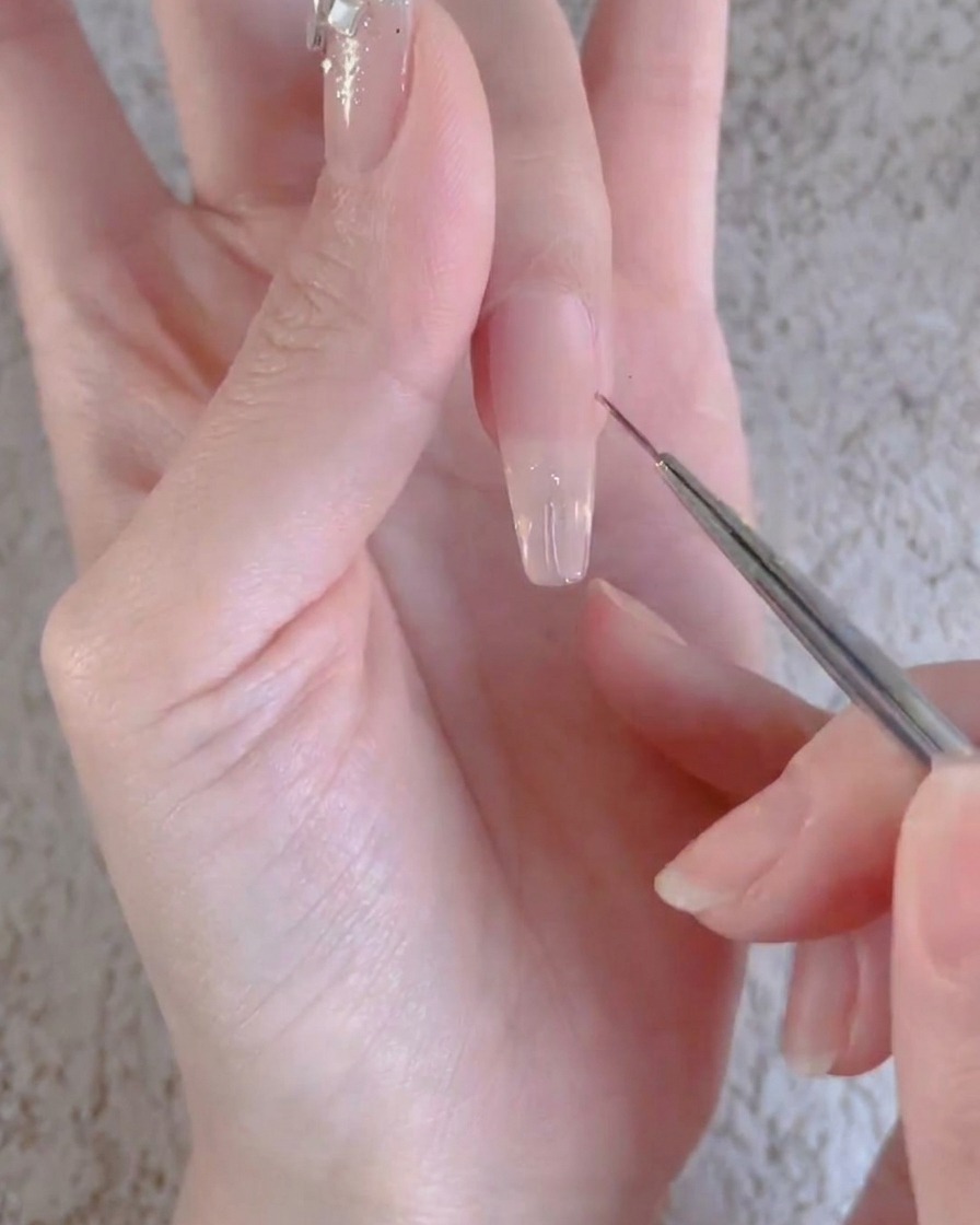 Un doigt avec une couche de gel transparent en train de catalyser sous une lampe à ongles professionnelle UV ou LED.