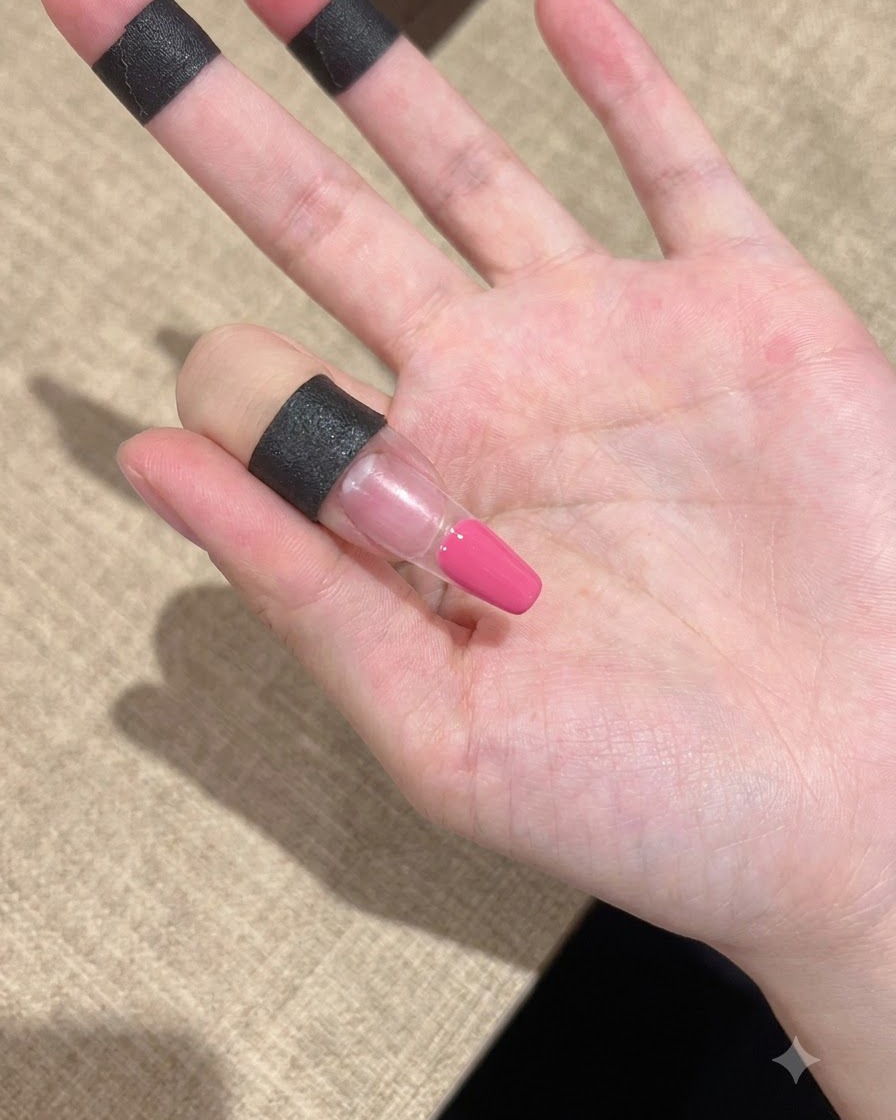 Gros plan sur un doigt avec du gel rose appliqué proprement sur la zone de la pointe.