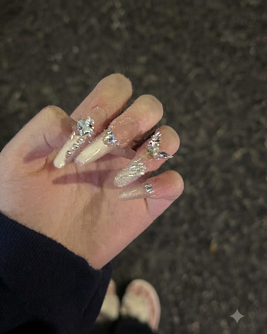 Un ajustement de la pose de la main mettant en valeur la réflexion de la lumière et la finition brillante sur les ongles décorés de strass.