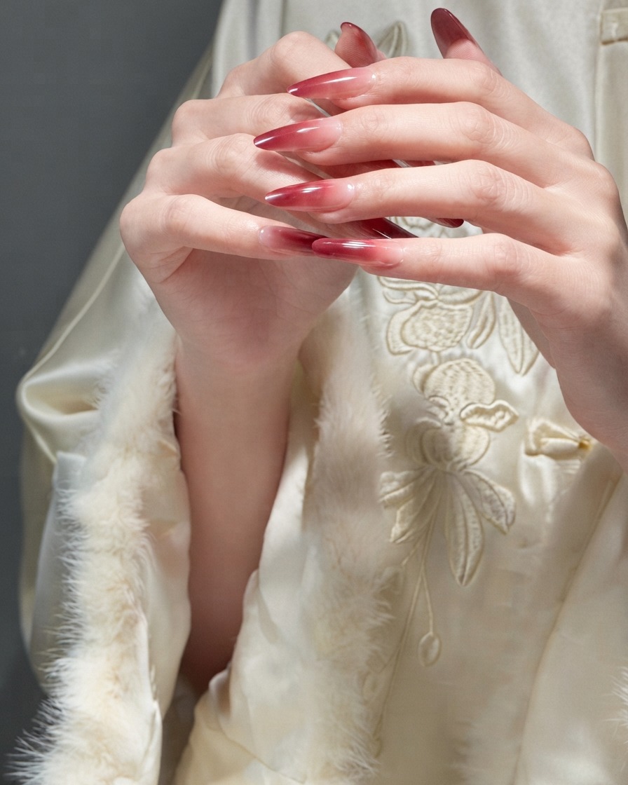 Doigts glissant délicatement les uns sur les autres pour démontrer la texture lisse des ongles en gel rouges finis.
