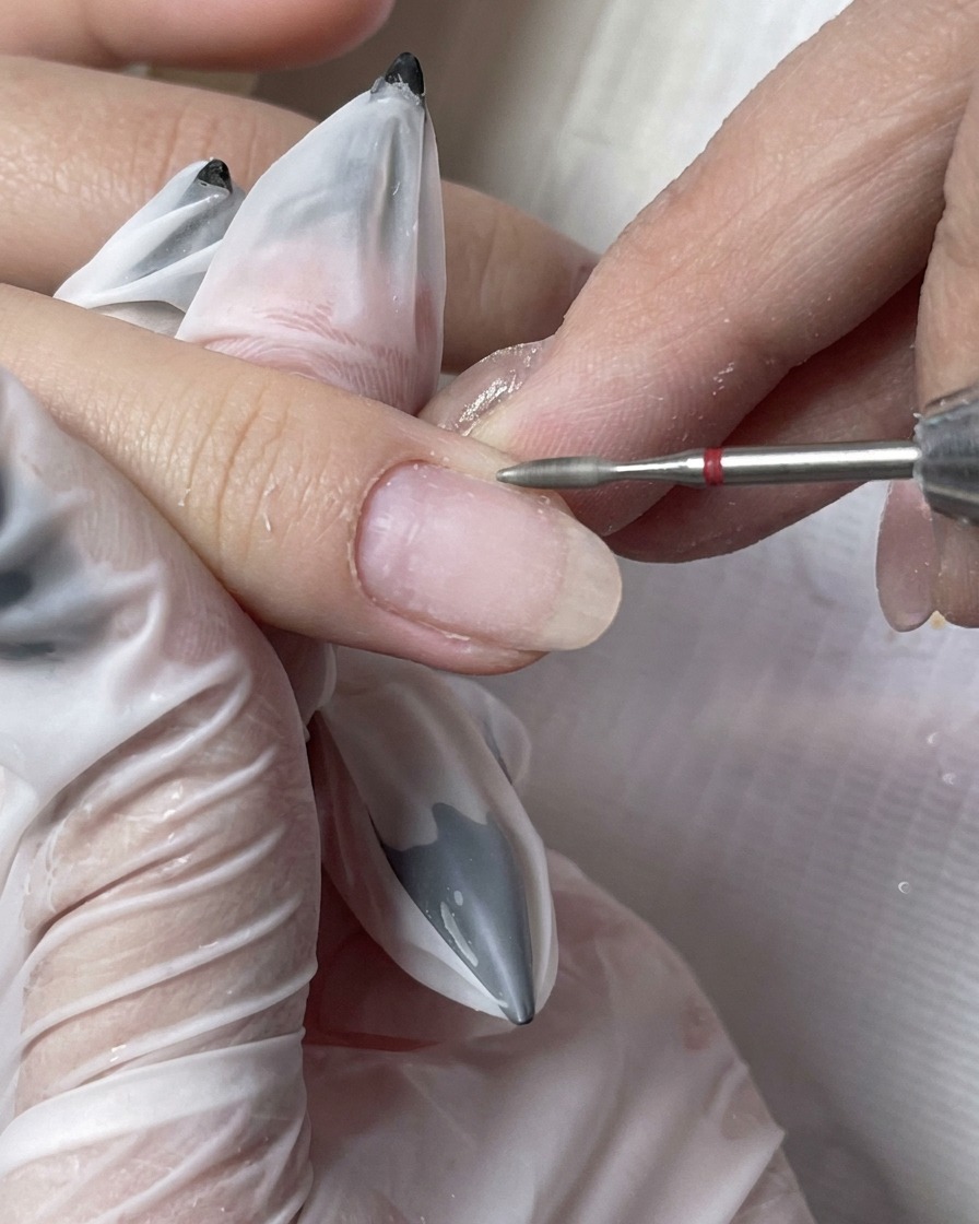 Une brosse à poussière éliminant les fines particules dun ongle fraîchement préparé.