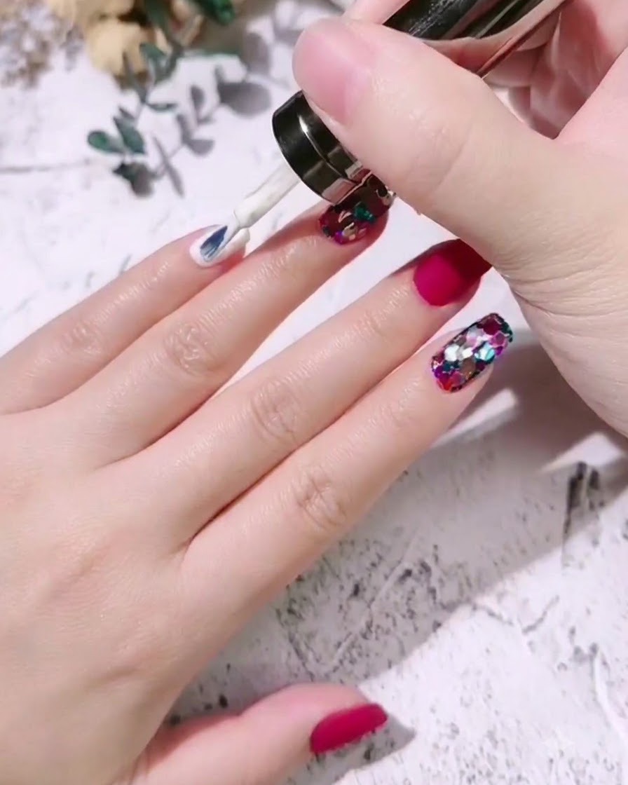 Un pinceau appliquant du vernis gel blanc lait sur longle dun auriculaire.