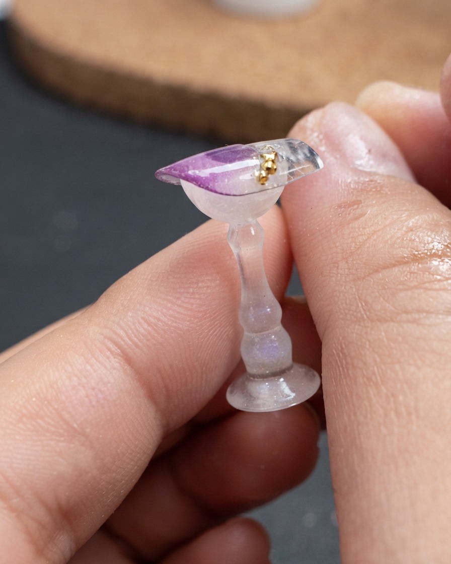 Gros plan de petites billes dorées placées en ligne courbe sur le dessus dune pièce dongle décorée.
